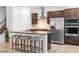 Modern kitchen featuring a center island with bar seating, stainless steel appliances, and tile flooring at 1323 Cerulean Ave, Henderson, NV 89002