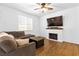 Comfortable living room featuring wood floors, a cozy sofa, fireplace, and a mounted television at 1323 Cerulean Ave, Henderson, NV 89002