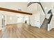 Spacious living room with high ceilings, wood beam, modern fireplace, staircase and luxury vinyl floors at 1724 Navajo Lake Way, Las Vegas, NV 89128