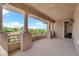 Spacious covered balcony featuring decorative columns, wrought iron railing, and views of lush landscaping at 1972 Alcova Ridge Dr, Las Vegas, NV 89135