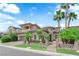 A beautiful two-story home boasts desert landscaping, a neutral exterior, and several palm trees at 1972 Alcova Ridge Dr, Las Vegas, NV 89135