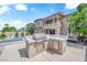 Outdoor kitchen with grill and stainless steel doors overlooks large pool and spa at 1972 Alcova Ridge Dr, Las Vegas, NV 89135