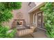 Cozy outdoor patio with stone fireplace, comfortable seating, and decorative wall art at 1972 Alcova Ridge Dr, Las Vegas, NV 89135