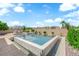 A backyard pool and spa with integrated stone and desert landscaping under a bright blue sky at 1972 Alcova Ridge Dr, Las Vegas, NV 89135