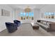 Bright sitting area with a contemporary leather couch, two blue swivel chairs and large windows at 1972 Alcova Ridge Dr, Las Vegas, NV 89135