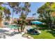 Lush backyard with pool, rock features, mature trees, and comfortable lounge area at 2101 Diamond Bar Dr, Las Vegas, NV 89117