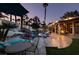 The backyard's tranquil nighttime ambiance features a pool, patio, and lush landscaping, creating a serene outdoor oasis at 2101 Diamond Bar Dr, Las Vegas, NV 89117