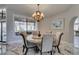 Formal dining room with chandelier and views of the outdoor waterfall at 2101 Diamond Bar Dr, Las Vegas, NV 89117