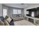 Cozy living room with a comfortable gray sofa, decorative pillows, a large television, and natural light at 2101 Diamond Bar Dr, Las Vegas, NV 89117