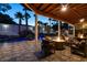 Relaxing covered patio with a fire pit, overlooking a pool with a waterfall feature at 2101 Diamond Bar Dr, Las Vegas, NV 89117