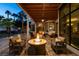 Inviting covered patio with stylish furniture, a fire pit, and views of the lush backyard at 2101 Diamond Bar Dr, Las Vegas, NV 89117