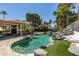 A stunning swimming pool with rock waterfall, sun lounge, and mature landscaping create a serene outdoor oasis at 2101 Diamond Bar Dr, Las Vegas, NV 89117