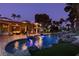 A beautifully lit swimming pool and manicured backyard with tropical landscaping provide a tranquil nighttime retreat at 2101 Diamond Bar Dr, Las Vegas, NV 89117