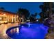 Backyard featuring a lit pool with a spa, rock waterfall, and covered patio area at 2101 Diamond Bar Dr, Las Vegas, NV 89117