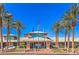 Exterior shot of community clubhouse framed by palm trees, blue sky, and white clouds at 2158 High Mesa Dr, Henderson, NV 89012