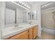 Bathroom with double sinks, oak cabinets, and access to a shower-over-tub at 2329 Sunrise Meadows Dr, Las Vegas, NV 89134