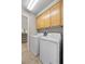 Bright laundry room features a washer and dryer with cabinets above for convenient storage space at 2329 Sunrise Meadows Dr, Las Vegas, NV 89134