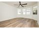 A bedroom featuring wood floors, a ceiling fan, and large windows that provide ample natural light at 25 Blue Valley Dr, Henderson, NV 89002
