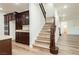 Bright hallway with hardwood floors leading to an upstairs staircase with wooden banister at 25 Blue Valley Dr, Henderson, NV 89002