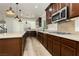 A spacious kitchen featuring wood-grain cabinets, stainless steel appliances, and a large island with pendant lighting at 25 Blue Valley Dr, Henderson, NV 89002