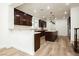 Beautiful kitchen with dark cabinets, an island, and wood-look flooring at 25 Blue Valley Dr, Henderson, NV 89002