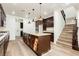 Open kitchen features a large island, wood-look floors and dark cabinetry at 25 Blue Valley Dr, Henderson, NV 89002