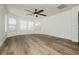 Inviting living room featuring wood-look floors, multiple windows, and a ceiling fan for ample natural light at 25 Blue Valley Dr, Henderson, NV 89002