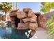 Outdoor pool featuring a custom rock grotto with a slide and small waterfall at 25 Blue Valley Dr, Henderson, NV 89002