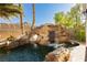 Beautiful backyard pool featuring a rock waterfall and lush greenery at 25 Blue Valley Dr, Henderson, NV 89002