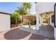 Backyard pool area with a tiki umbrella, rock waterfall, and lush landscaping, perfect for outdoor relaxation at 25 Blue Valley Dr, Henderson, NV 89002