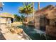 Resort-style pool with a rock waterfall, palm trees, and shaded seating offering the ultimate backyard oasis at 25 Blue Valley Dr, Henderson, NV 89002