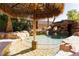 Beautiful pool features a grotto, slide, lush landscaping and tiki umbrella table at 25 Blue Valley Dr, Henderson, NV 89002