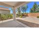 A covered patio looks out onto a backyard featuring desert landscaping and a block wall at 2550 Evening Twilight Ave, Henderson, NV 89044