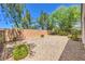 A backyard featuring neutral desert landscaping is enclosed by a block wall and black metal fence at 2550 Evening Twilight Ave, Henderson, NV 89044