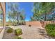 A backyard enclosed by a block wall and black metal fence has desert landscaping at 2550 Evening Twilight Ave, Henderson, NV 89044