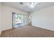 Carpeted bedroom featuring a sliding glass door to the backyard and a ceiling fan at 2550 Evening Twilight Ave, Henderson, NV 89044