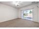 Cozy bedroom with carpet, sliding door to patio, and neutral color palette at 2550 Evening Twilight Ave, Henderson, NV 89044