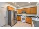 Functional kitchen featuring stainless steel fridge, ample cabinetry, and convenient access to the exterior door at 2550 Evening Twilight Ave, Henderson, NV 89044