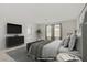 Staged bedroom with large windows, a television, and neutral paint at 2628 Ferrara St, Henderson, NV 89044