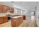 Open kitchen with stainless steel appliances, a center island, and wood-look flooring at 2628 Ferrara St, Henderson, NV 89044