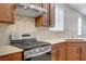 Close-up of stainless steel stove, range hood and tiled backsplash in a modern kitchen setting at 2628 Ferrara St, Henderson, NV 89044