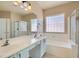 Bathroom featuring double sinks, a soaking tub, and a separate shower at 2668 Ivoryhill St, Las Vegas, NV 89135
