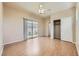 This bedroom features wood floors, a ceiling fan, closet, and sliding glass door access to the patio at 2668 Ivoryhill St, Las Vegas, NV 89135