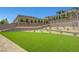 Large backyard with lush artificial grass and nicely planted retaining wall, perfect for outdoor activities at 281 Gandara St, Las Vegas, NV 89138