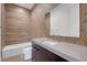 Elegant bathroom featuring a vanity with a stone countertop and textured tile accent wall at 281 Gandara St, Las Vegas, NV 89138