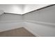 A simple walk-in closet with a rod for hanging clothes and neutral carpeting at 281 Gandara St, Las Vegas, NV 89138