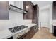 Modern kitchen with stainless steel stove, range hood, and dark wood cabinets at 281 Gandara St, Las Vegas, NV 89138