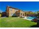 Expansive backyard featuring a manicured lawn, covered patio, and pool at 29 Blue Valley Dr, Henderson, NV 89002