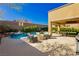 Outdoor living space with pool, covered patio with seating and fire pit featuring beautiful landscaping and mountain views at 29 Blue Valley Dr, Henderson, NV 89002