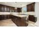 Bright kitchen with dark wood cabinetry, granite counters, and a large center island at 29 Blue Valley Dr, Henderson, NV 89002